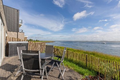 025 Vakantiewoning aan het strand   tuin en terras met haven  